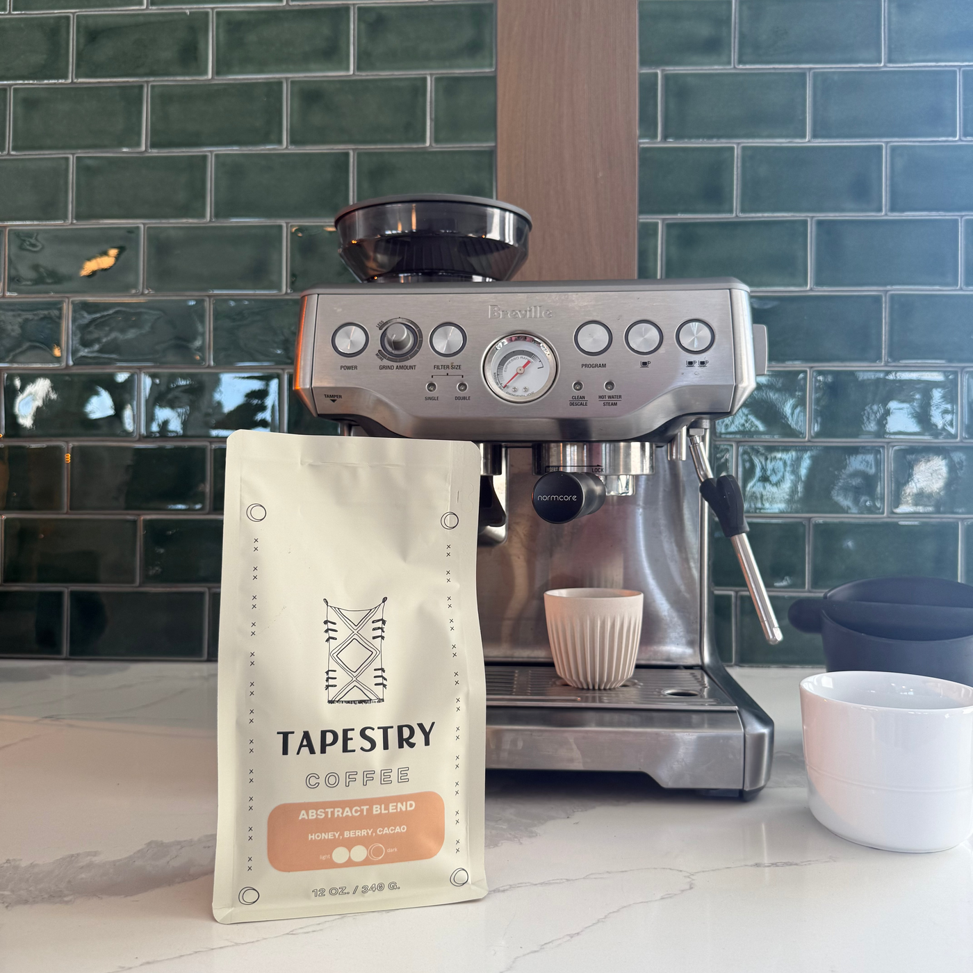 Tapestry Coffee Abstract Blend next to a home espresso machine